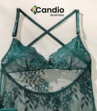 Un ensemble de nuisette et string en dentelle verte à motif floral et bretelles croisées dans le dos est présenté sur un fond uni. Le nom de la marque "Candio Business" est imprimé au-dessus du haut.